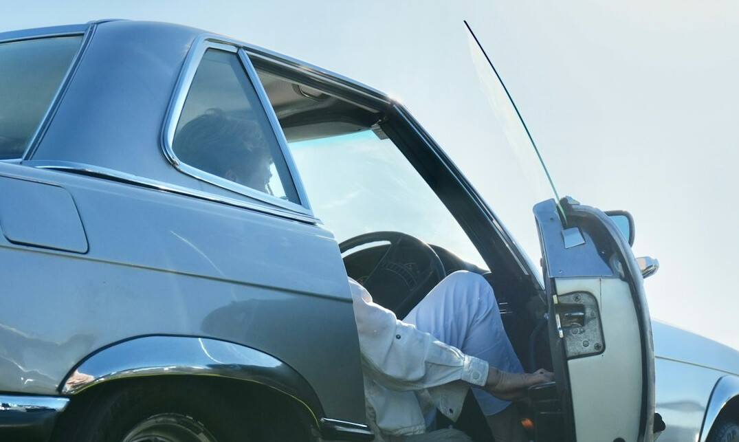 Technician removing a dent from a car door without paint